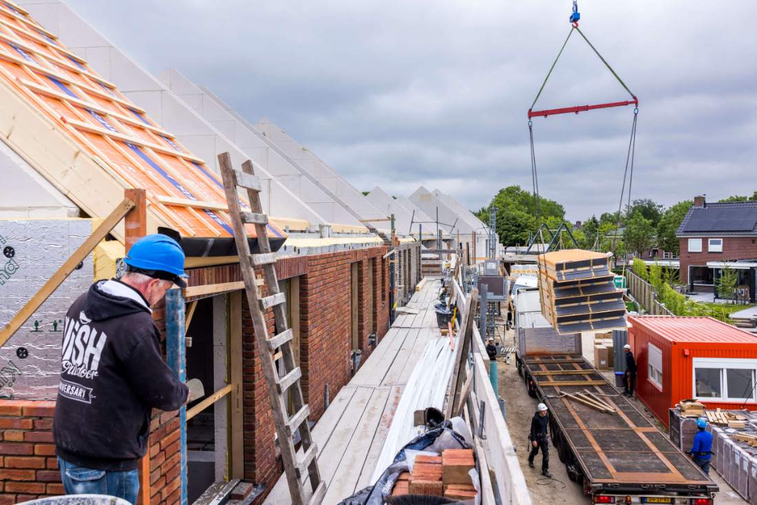 Metselaar op een bouwplaats met materialen van Wouters