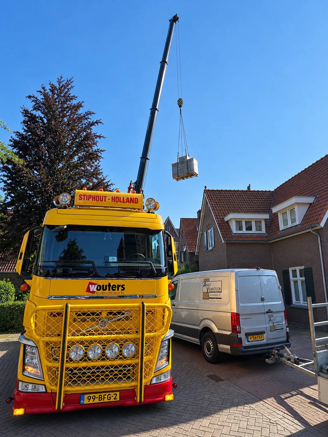 Kraanwagen van Wouters lost bouwmaterialen op een bouwplaats